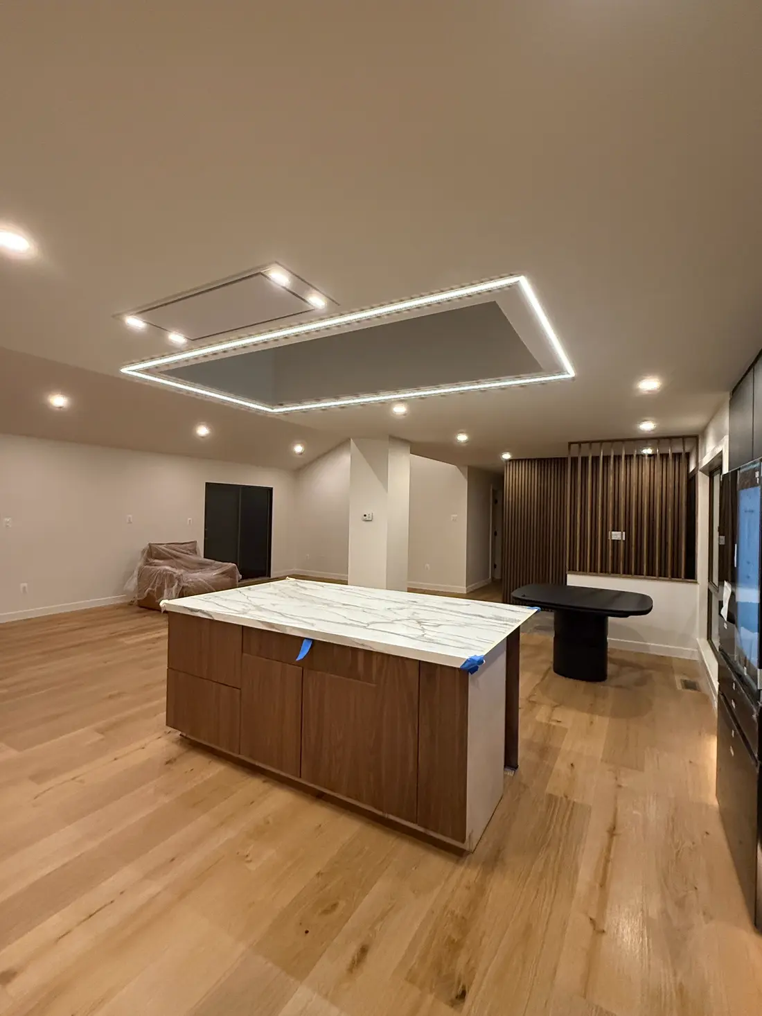 Open-concept home addition with quartz island, wood paneling and LED cove lighting in Northern Virginia