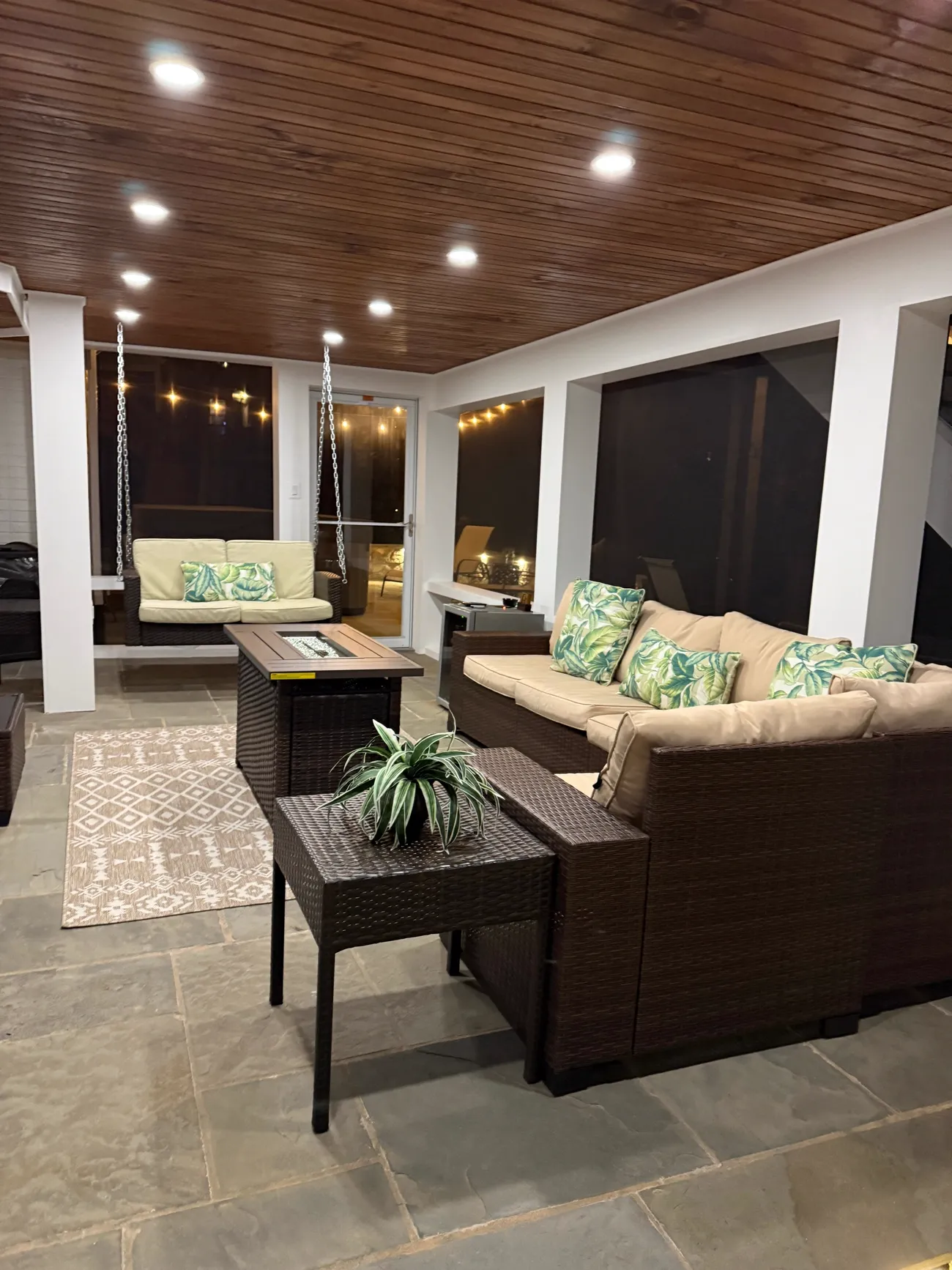 Cozy screened porch interior at night with wood ceiling, recessed lighting and lounge seating in Northern Virginia